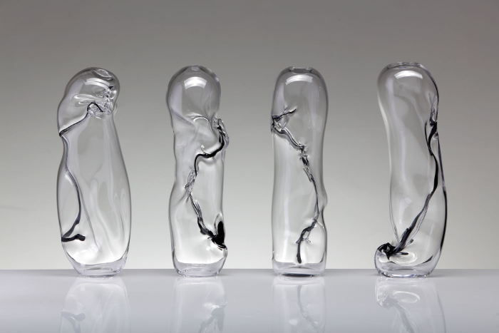 A series of four blown glass pieces called Flux Noir made with clear glass and sealed with uneven seams of white and black glass.