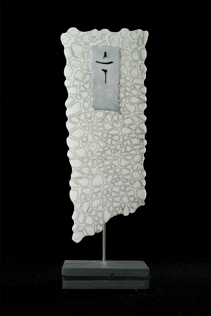 Kiln-formed glass sculpture featuring chemical reactions to create a pattern.