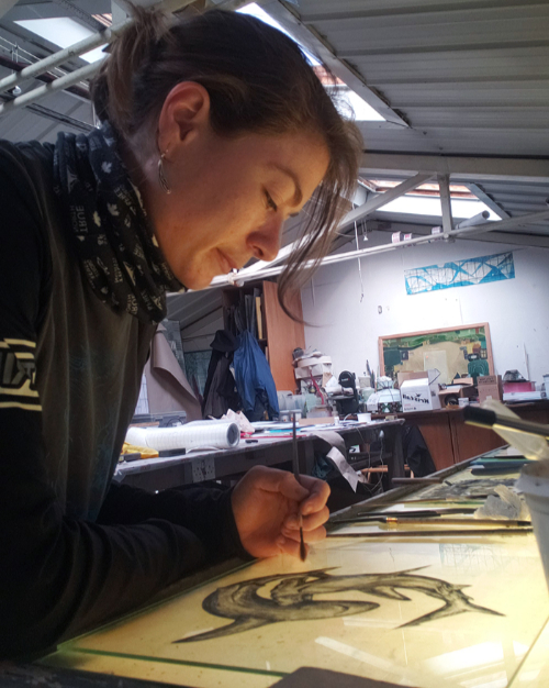 Julia Gonyou painting on glass in the studio.