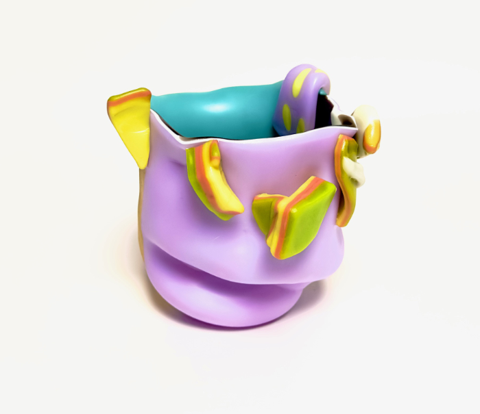 A warped shaped solid pink glass vessel with aqua interior and sandwiched pieces attached and overhanging in a sandwich of lime, orange and yellow glass.