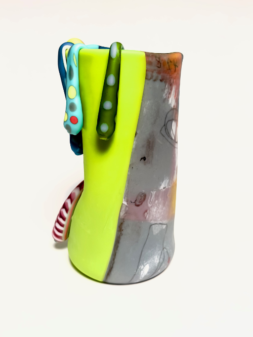 A tall glass vase in lime green and reverse-painted grey with multicoloured overhanging 'droplets' in other bright colours.