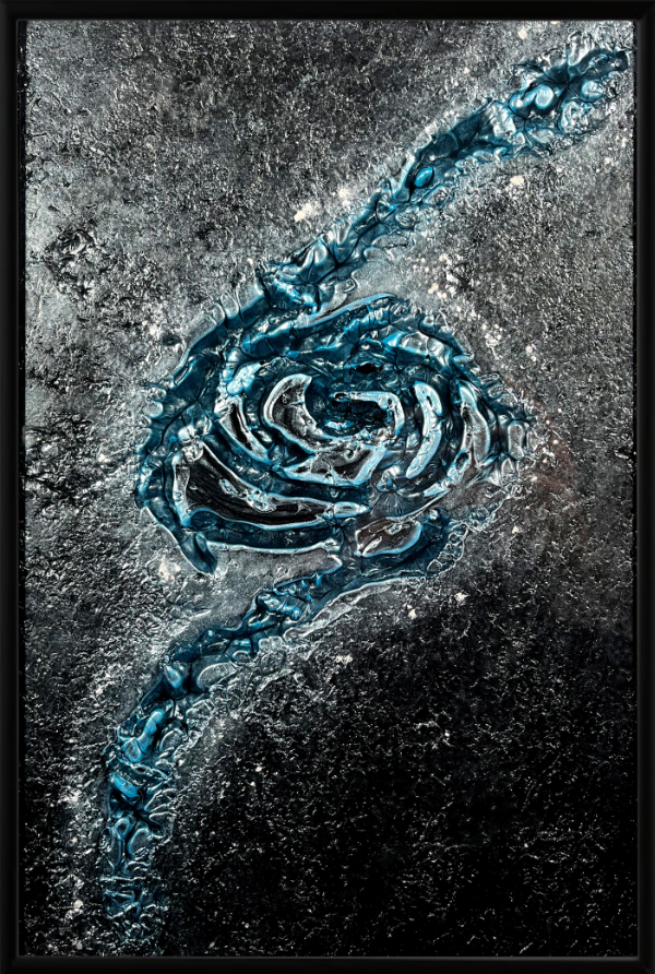 Glass artwork called Aqua Mystique is an abstract design of a blue swirl in the middle of a grey-black background.