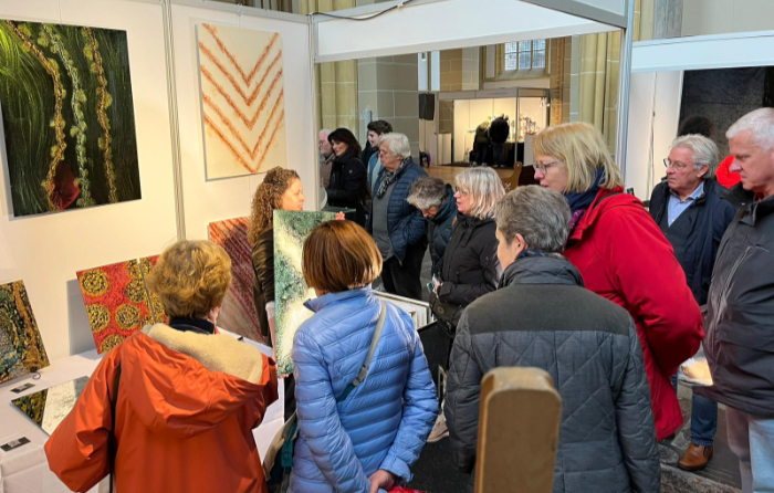 Carolin Zibulka on her stand at Glassexpo Zutphen 2023 talking to customers.