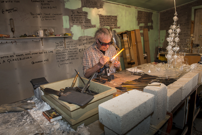 Ian Pearson at the lamp working bench in his studio creating glass sculptures.