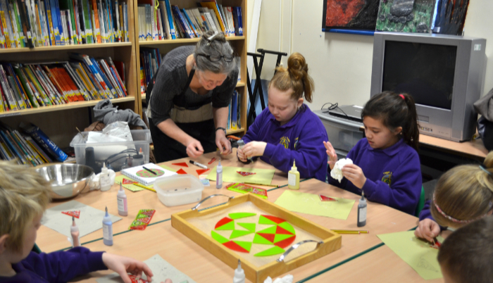 Linda Norris helping primary school children in Wales to make glass bowls.
