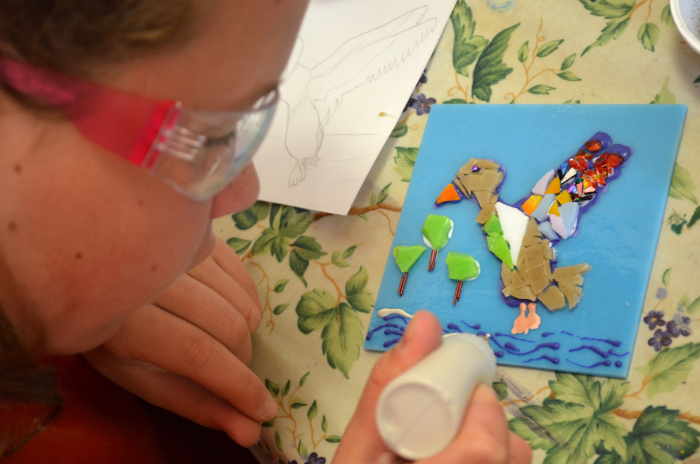 A child working with an aloe vera frit pen to decorate the Narberth School Quilt.